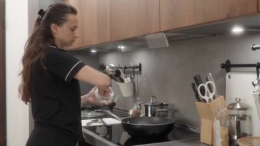 Bir kadın yemeği yapışmaz bir tavada tuzlar ve sonra da kapakla kaplar. Ev hanımı kahvaltılık, öğle yemeği ya da akşam yemeğini evde elektrikli sobanın üstünde hazırlar..