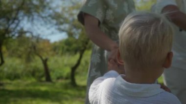 Güneşli bir yaz gününde bir çift çocuklarıyla parkta yürüyüşe çıkar. Annem elini bebeğe uzatıyor, ve el ele tutuşuyorlar, bebek arabasını iten babamın yanındaki yolda yürüyorlar..