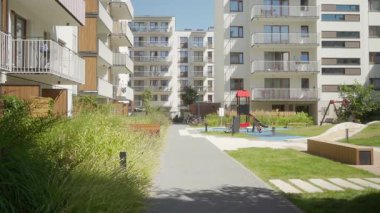 Çocuk parkı olan, çocuk parkı olan, manzaralı, bankları olan ve yaz günü kapalı bir alanda yaya geçitleri olan modern, çoklu aile apartmanları kompleksi..