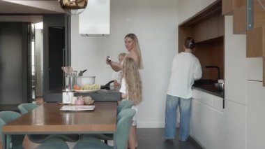 Anne ve kızları krep hamurunu son kez karıştırmak için mutfakta toplandılar. Yemek pişirmeden önce, takım çalışmasını paylaşmadan önce, tutarlılığın mükemmel olduğundan emin olmak için spatula kullanırlar..