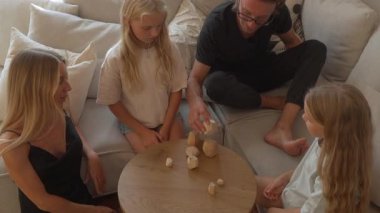 Yaratıcı bir ahşap dizme oyunu oynayan, takım çalışmasını somutlaştıran ve değerleri paylaşan bir aile. Baba, kızlarına denge ve hassasiyet konusunda akıl hocalığı yapar, yaratıcılığı, uyumu ve evde kaliteli zaman geçirmeyi teşvik eder..