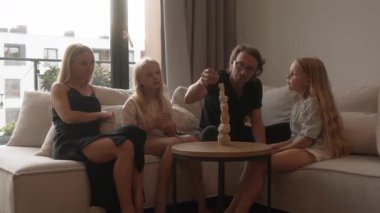 Baba 'nın yeni yapılmış ahşap kulesi çöker, kızlar parçaları yakalamaya çalışır. Aile, evdeki bu gelişim oyununda denge ve dengesizliği öğrenme ve ortak neşe anlarına gülüyor..