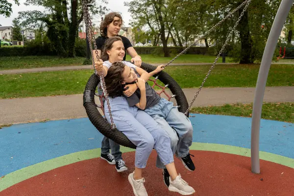 Neşeli bir aile, bir anne ve iki oğul, büyük yuvarlak bir yuvada gülüp eğleniyorlar. Bir parkta salıncakta sallanıyorlar. Kaygısız bir oyun anını yakalıyorlar ve aile bağlarını kuruyorlar..