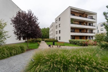 Modern yerleşim merkezinin bahçesinde bahçe düzenlemesi yapılmış, parkı da dokunaklı. Çimenli yollar, çimenler, süslü otlar, ağaçlar ve banklar sakinler için ortak bir davet alanı oluşturuyor..