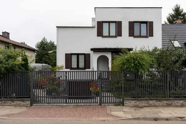 Pencere panjurlu ev, metal bir çit ve kapı ile korunuyor. Bu bariyer ev sakinlerine mahremiyet, erişim kontrolü ve emlak güvenliği sunar..