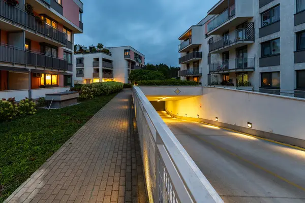 Modern bir yerleşim yerinin garajına açılan rampa. Güvenli bir park yeri öneriyor, yan kaldırımlı yaya geçidi araziden geçişi sağlıyor..