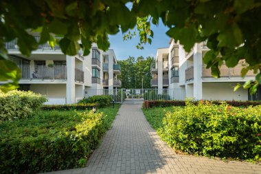 Özel bir yerleşim alanının içindeki gözlerden uzak bir geçit kapalı bir kapıya çıkar. Apartman binaları olan güvenli, güvenlikli bir topluluk özel ve sakin bir yerleşim ortamı yaratıyor..