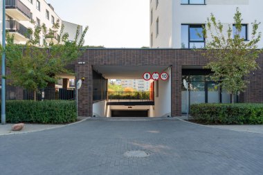 Modern bir konut kompleksine entegre edilmiş bir yeraltı otoparkına giriş. Yeni gelişmeler genellikle yerleşik araçlar için bu tip entegre park yerlerini içerir.