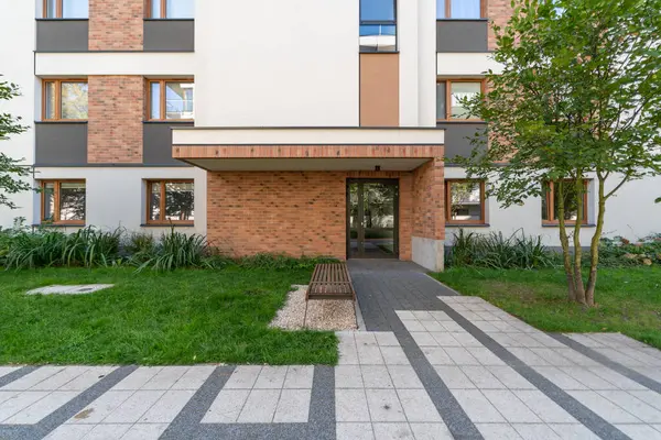 Modern bir apartmanın girişinde bulunan ahşap bir bank. Bu basit konfor konut sakinleri için günlük rahatlık sağlar..