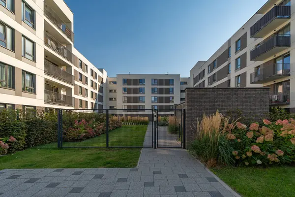 Mahalle sakinleri için kapalı, özel bir çimenliğe erişimi olan güvenli bir kapıya giden yol. Modern bir konutun bahçesinde sadece yeşil alan ve konfor..