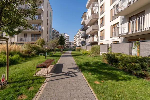 Modern bir konutun içinden geçen uzun yaya yolu olan yeşil bir koridor. Apartman binaları arasındaki peyzaj geçidinde sakinler için çimenler, ağaçlar ve banklar yer alıyor..