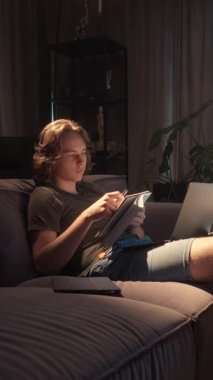 Genç bir çocuk eğitim için teknolojiyi kullanır, bir dizüstü bilgisayar ve bir not defteriyle çalışır. Bu, pozitif ekran süresini ve dijital araçların modern öğrenme ve ev ödevindeki rolünü gösterir.