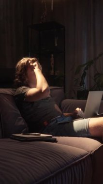 Bitkin düşmüş bir öğrenci yorgun yüzünü ovuşturur ve işini bitirir. Dizüstü bilgisayarını kapatıyor, çok ihtiyaç duyduğu dinlenmeden önce ödevini veya projesini tamamlıyor..