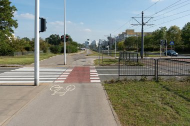 Kırmızı bir trafik ışığı yayalara ve bisikletçilere karmaşık bir şehir kavşağında beklemelerini söylüyor. Bu sistem Varşova 'daki çok modallı geçitte güvenlik hareketlerini düzenliyor.