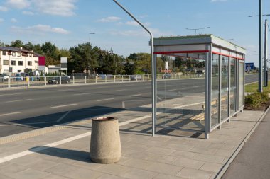 Modern bir cam otobüs durağı barınağı toplu taşıma yolcuları için bir bekleme alanı sağlar. Varşova 'daki bu boş durak, şehrin şehir ulaşımının ve işe gidip gelen altyapısının bir parçası..