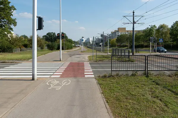 Kırmızı bir trafik ışığı yayalara ve bisikletçilere karmaşık bir şehir kavşağında beklemelerini söylüyor. Bu sistem Varşova 'daki çok modallı geçitte güvenlik hareketlerini düzenliyor.