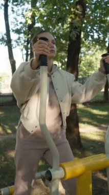 Kamu parkında vücut çalışıp kilo vermeye kararlı bir kadın. Açık hava kardiyo egzersizi sağlıklı bir yaşam tarzının ve kendine bakmanın bir parçası..