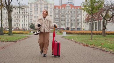 Güzel bir kadın Varşova 'ya gelir, bavuluyla parkta yürür. Bu şık gezgin tatilde, gezinin ve şehrin tarihi mimarisinin tadını çıkarıyor..