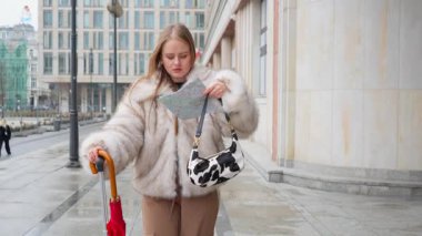 Polonya 'nın Varşova şehrinde bir turist, kağıt harita okuyarak yolunu bulmaya çalışıyor. Mimariye ve haritaya bakıyor, sokaklarda geziniyor..