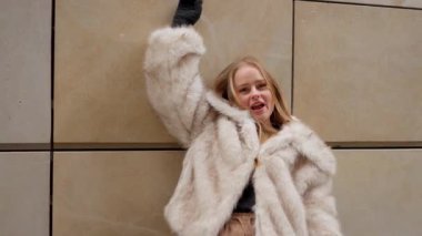 Güzel bir kadın yeni kış koleksiyonundan şık bir eko kürk mankünün modelliğini yapıyor. Bu klip perakende reklamlar, sosyal medya kampanyaları ve moda mağazalarına yeni gelenlerin tanıtımı için mükemmel..