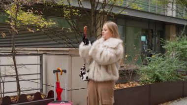 Kadın bir seyahat blogcusu sosyal medya takipçileri için şehir turunu düzenliyor. Akıllı telefonunu tutuyor, kameraya konuşuyor ve abonelerine manzaraları gösteriyor..