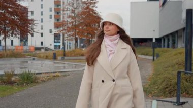 Derin düşüncelere dalmış genç bir kadın modern şehir manzarasında barışçıl bir yürüyüş yapıyor. Şehirde huzur ve yalnızlık bularak, sessiz ve düşünceli bir anın tadını çıkarıyor..