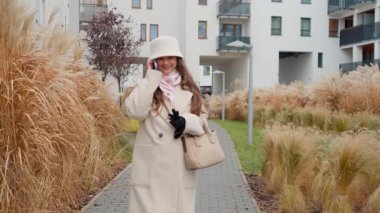 Sakin bir kadın, serin bir sonbahar gününde mahallesinde acele etmeden yürürken telefonla konuşur. Yavaş bir yaşam felsefesini benimseyerek huzurlu bir sonbahar anının tadını çıkarıyor..