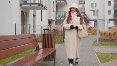 Genç bir kadın dinlenmek için bir konutun avlusundaki banka yürür. Oturdu, cep telefonunu çıkardı ve sosyal medyayı karıştırmaya ya da mesaj atmaya başladı..