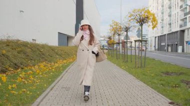 Şehirde sakin bir sonbahar gününde bir kadın cep telefonuyla yürüyüp konuşur. Arkadaşını keyifli bir şekilde arıyor. Keyifli bir gezinti ve dostça bir sohbetten hoşlanıyor..