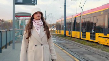 Genç bir kadın tramvaydan indi ve eve giderken platformda yürüdü. Bir şehir yolcusu günlük seyahatini bitirip akşamları mahallesindeki durağa geliyor..