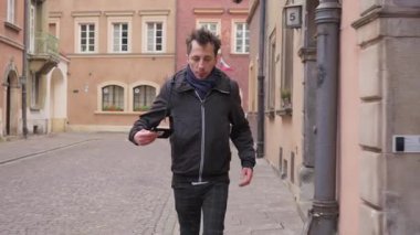 Randevu için acele eden bir adam, şehir caddesinde hızla yürür. Acelesi var ve geç kalmamak için saati ve yönleri kontrol etmek için telefonuna kısa bir bakış atıyor..