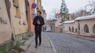 Tek başına yürüyen bir adam Varşova 'nın Eski Kasabası' ndaki sessiz ve dar bir kaldırım taşını keşfediyor. Düşünceli bir şekilde tarihi mimariyi inceliyor, yalnız başına huzurlu bir anın tadını çıkarıyor..