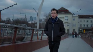 Günbatımında modern bir şehrin ufuk çizgisine karşı yaya köprüsünde tek başına yürüyen bir adam. Düşünceleriyle baş başa, Polonya 'nın Varşova kentsel manzarasını gözlemliyor..