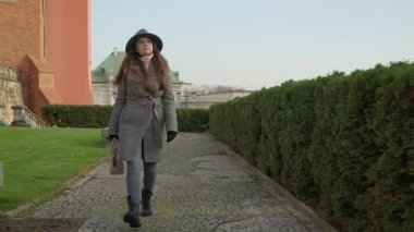 Varşova 'yı gezen zarif bir kadın Kraliyet Kalesi' nin güzel bahçelerinde kaldırım taşı patikasında yürüyor. Polonya 'nın önemli bir tarihi yeri ve turistik yeri..