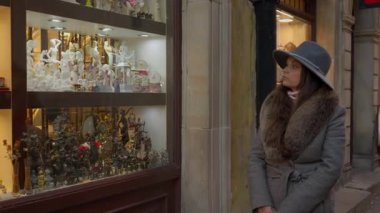 Düşünceli bir kadın mücevher sergisine bakarken bir seçim yapmaya çalışırken satın almayı düşünüyor. Karar verme, seçeneklerin değerlendirilmesi ve tüketici seçimi kavramı.