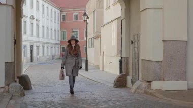 Tarihi bir kemerden zarif bir kadın çıkıyor Varşova 'nın Eski Kasabası' ndaki bir kaldırım taşı caddesine doğru yürüyor. Geliş, geçiş ve yeni bir yeri keşfetme kavramı..