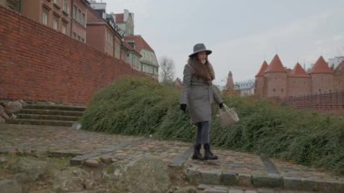 Bir dişi turist Varşova Barbican 'ının arazisini keşfediyor, antik ortaçağ savunma duvarları ve Eski Şehir' in tahkimatları boyunca yürüyor. Tarih ve seyahat kavramı.