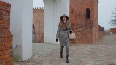 Şık bir kadın, bir turist, Varşova Barbican 'ının kapısından girer. Avrupa 'daki bir şehir tatili sırasında tarihi simgeleri ve kültürel mirası keşfetme kavramı..
