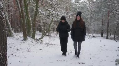 Karlı bir kış ormanında bir anne ve oğlu kameraya doğru yürüyor. Aile yan yana geziyor, sakin bir muhabbet ediyor. Güzel bir doğa ortamında doğa yürüyüşü..
