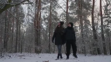 Bir çocuk kış ormanındaki bir aile yürüyüşü sırasında annesine bir şey gösterir. Yukarı bakarlar, konuşurlar ve gülümserler, keşif anlarını paylaşırlar. Doğanın tadını çıkaran bir ebeveyn ve çocuk.