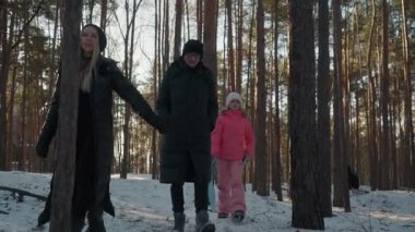 Genç ve mutlu bir çift, bir kış ormanında yürürken bir kadın, bir ağacın etrafında neşeyle döner ve kocasına romantik bir öpücük verir, aile gezisi sırasında anlık bir aşk anı yaşar..