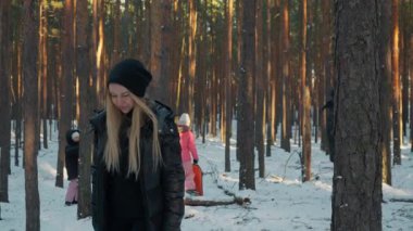 Sakin bir kadın kış parkında yürüyor, huzurlu bir anın tadını çıkarıyor. Arka planda, mutlu ailesi onun dingin ruh hali ile onların neşeli aktiviteleri arasında bir tezat oluşturuyor..