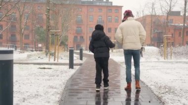 Kış kar yağarken iki kardeş şehir kaldırımında kameradan uzaklaşıyor. Küçük kardeş büyük olana destek veriyor. Aile bağını, güveni ve dostluğu simgeliyor..