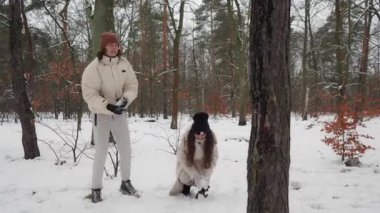 Bir anne ve genç oğlu, karlı bir kış ormanında oyun oynarken eğleniyor. Mutlu bir aile ağaçta kartopu atar, atış taliminin tadını çıkarırlar. Paylaştığımız neşe ve takım çalışması anı.