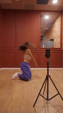 Bir kadın jimnastikçi esnekliğini ve gücünü esnek ve akrobatik öğelerle gösterir. Bu yetenekli sanatçı dans çalışmasında inanılmaz bir vücut kontrolü ve esnekliği gösteriyor..