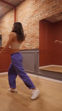 Mutlu genç bir kadın stüdyoda dans ederken kendini özgür hisseder. Bu enerjik solo performansı, onun hareket tutkusunun neşeli bir ifadesidir. Sevilen bir hobi ve yaşam tarzı..