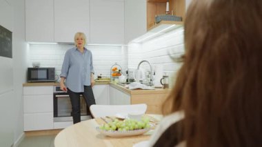 Yaşlı bir anne, yetişkin kızıyla mutfakta canlı bir konuşma yapar. Bir kadın, bir aile toplantısı sırasında dikkatlice dinleyen çocuğuyla hikâyeler paylaşır ve konuşur..