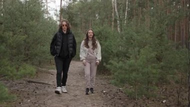 Genç bir çift orman yolunda yürürken derin bir sohbetin içindedir. Kadın, bir hikaye anlatırken jest yapar, eşiyle yemyeşil bir çam koruluğunda rahatça yürüyüş yapar..