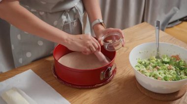 Kırmızı bir tavayı erimiş tereyağı veya yağla yağlamak. Bir kadın pasta, pasta ya da puf böreği pişirmeden önce fırçayla fırçayla fırça hazırlar..
