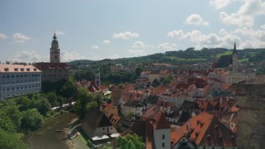 Panoramic cityscape of Cesky Krumlov in the Czech Republic on a sunny summer day. View of the historic old town, famous castle tower, and Vltava river. A popular european tourist destination.